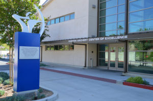 The front of Easton Archery Center of Excellence Building in Chula Vista, a nearby sculpture displays a quote from Chairman Jim Easton