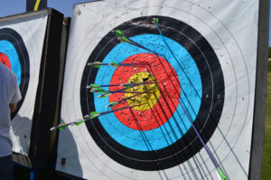 Archery target with arrows sticking into different parts of the target