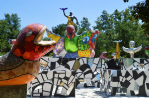 Entrance of Queen Calafia's Magical Cirlcle Garden featuring a wall with a vibrant red and orange snake and a black, white and mirrored tile mosaic maze